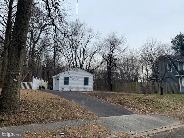 a view of white house with a yard covered in snow