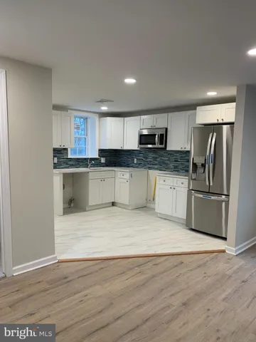 a kitchen with granite countertop a refrigerator and a stove top oven