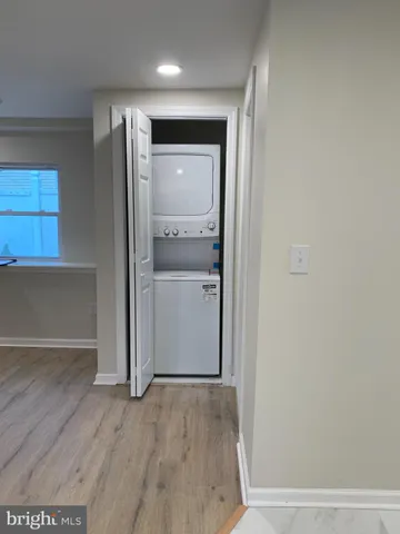 an empty room with wooden floor cabinet and door