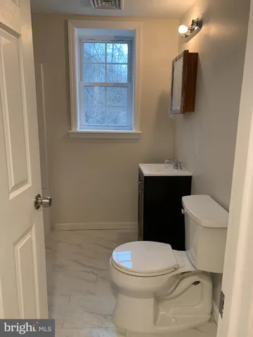 a white toilet sitting next to a bathroom sink and vanity