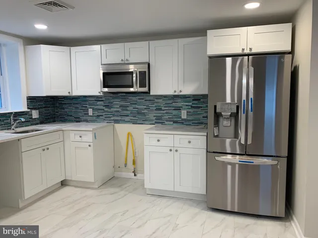 a kitchen with granite countertop white cabinets and stainless steel appliances