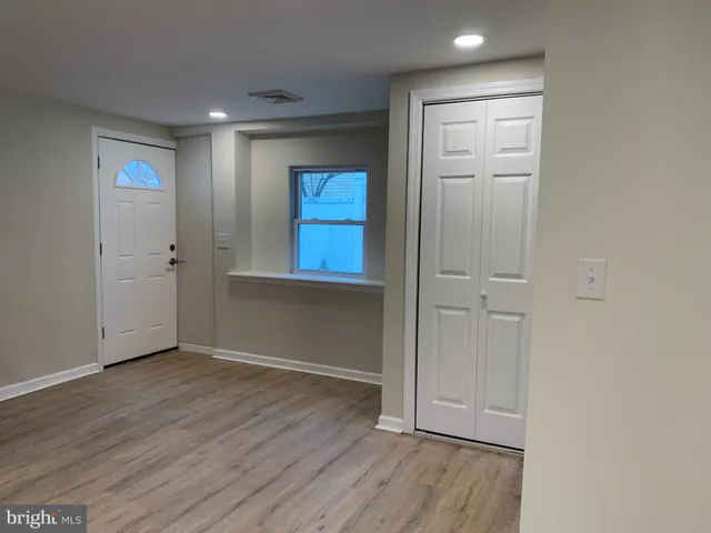 an empty room with wooden floor and closet area