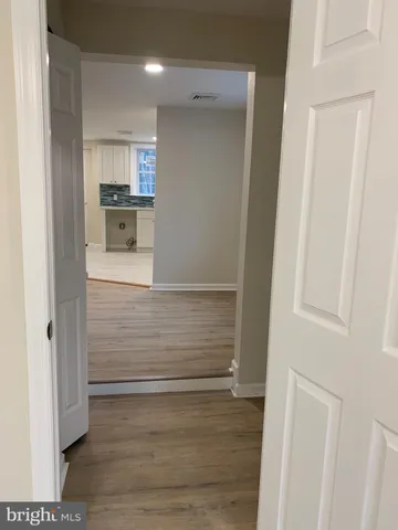 a view of kitchen and hallway with wooden floor