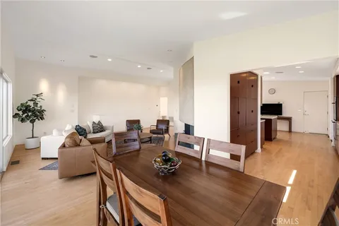 a living room with furniture kitchen view and a potted plant