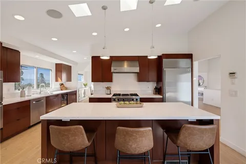 a kitchen with a dining table chairs and refrigerator