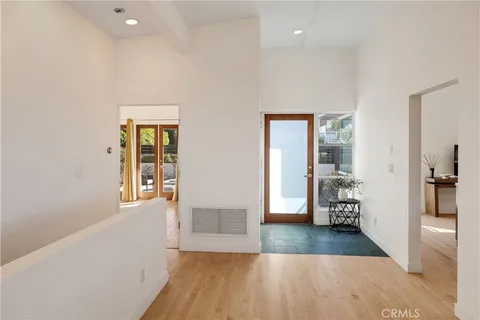 a view of a hallway with wooden floor and a living room