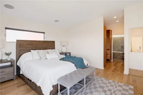 a spacious bedroom with a bed and wooden floor