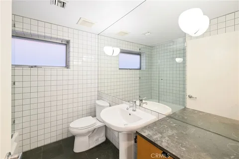 a bathroom with a sink a toilet and mirror