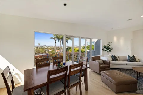 a living room with furniture a chandelier and a floor to ceiling window