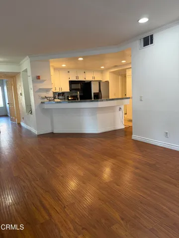 a view of kitchen with stainless steel appliances wooden floor