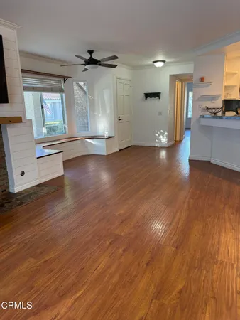 a view of a kitchen with wooden floor and a window