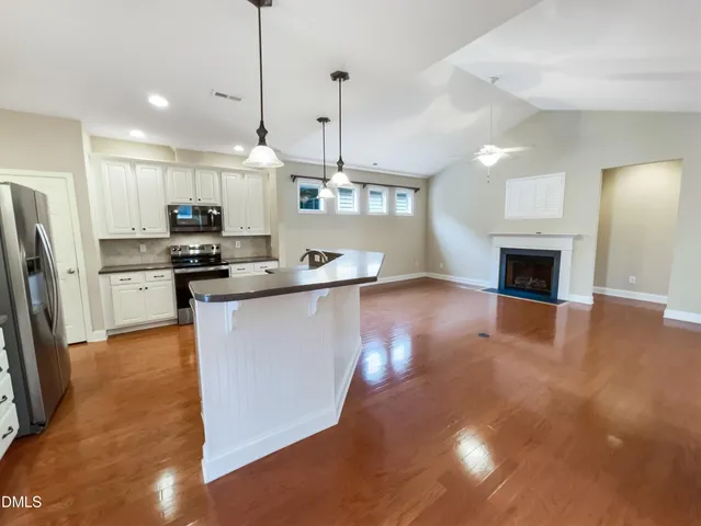 a large kitchen with stainless steel appliances granite countertop a stove a refrigerator a sink and a microwave