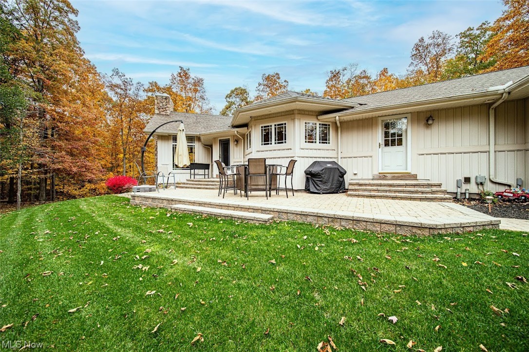 12151 Girdled Road Painesville, OH 44077 - Photo 4 of 35 Back of house featuring a patio area and a lawn