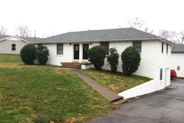 a view of a house with a yard and potted plants