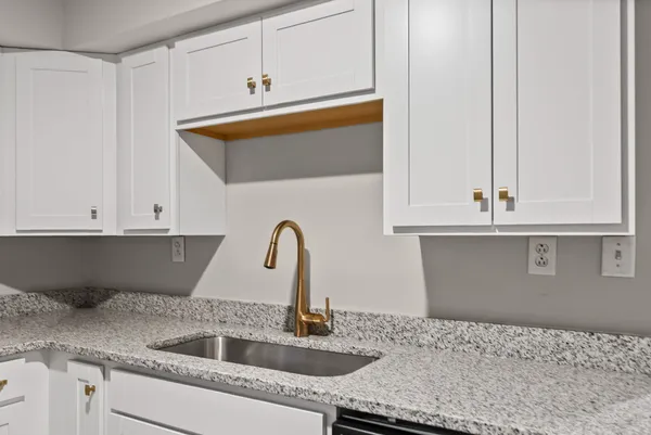 a kitchen with granite countertop a sink and cabinets
