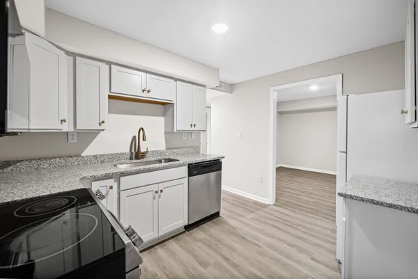 a kitchen with stainless steel appliances granite countertop a sink stove and cabinets