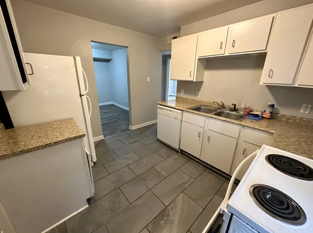 a kitchen with a sink a stove and cabinets