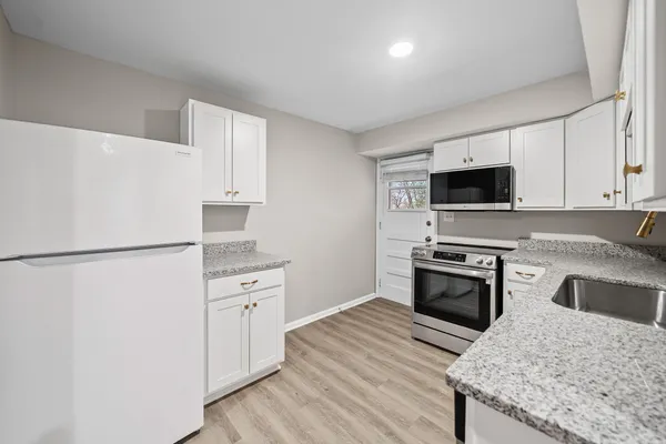 a kitchen with stainless steel appliances granite countertop a refrigerator stove microwave and sink