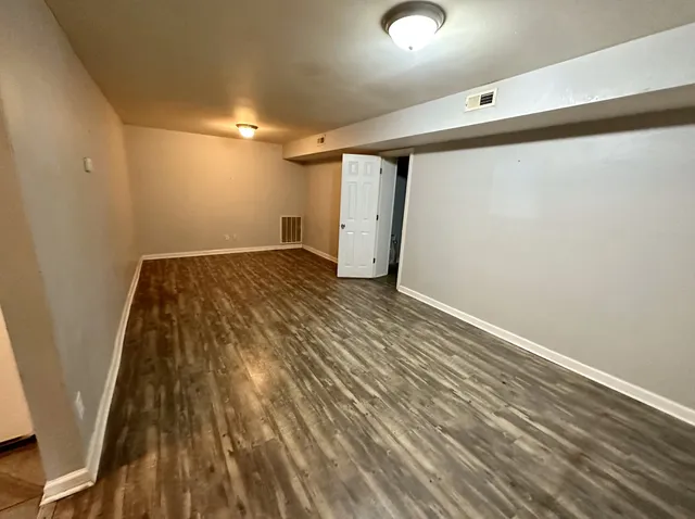 a view of empty room with wooden floor