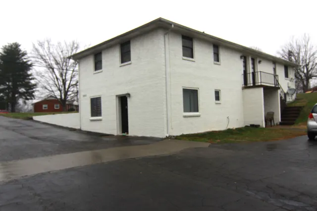 a view of a white house with a yard
