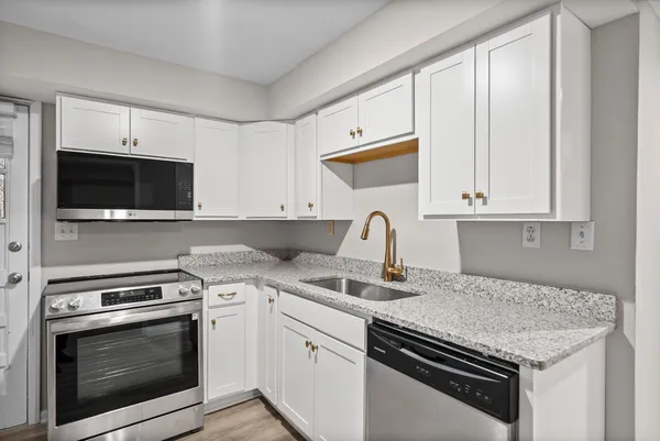a kitchen with stainless steel appliances granite countertop a stove microwave and sink