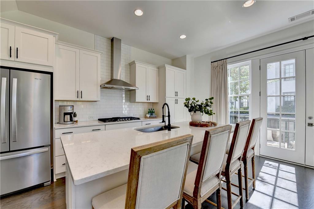 6602 Sterling Drive, Unit 688 Atlanta, GA 30328 - Photo 13 of 34 a kitchen with stainless steel appliances a stove a refrigerator a dining table and chairs