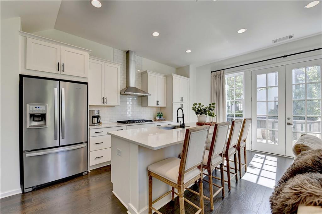 6602 Sterling Drive, Unit 688 Atlanta, GA 30328 - Photo 3 of 34 a kitchen with stainless steel appliances a refrigerator a stove a dining table and chairs