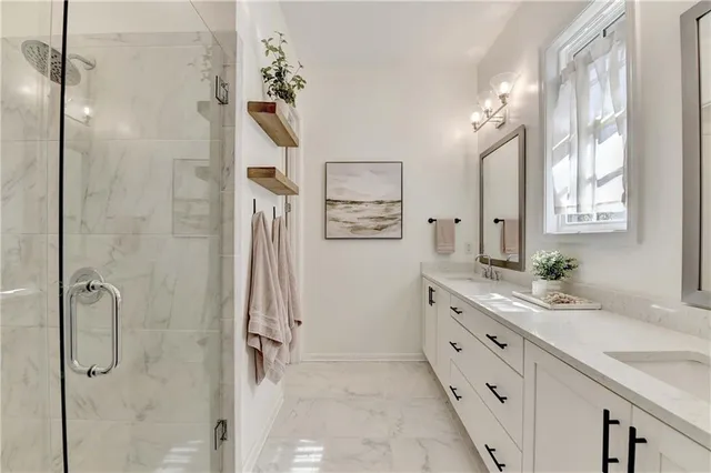 a bathroom with a granite countertop sink a mirror a shower and a bathtub