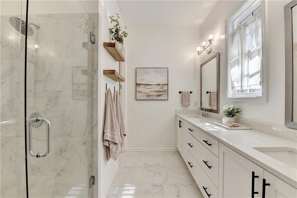 6602 Sterling Drive, Unit 688 Atlanta, GA 30328 - Photo 7 of 34 a bathroom with a granite countertop sink a mirror a shower and a bathtub