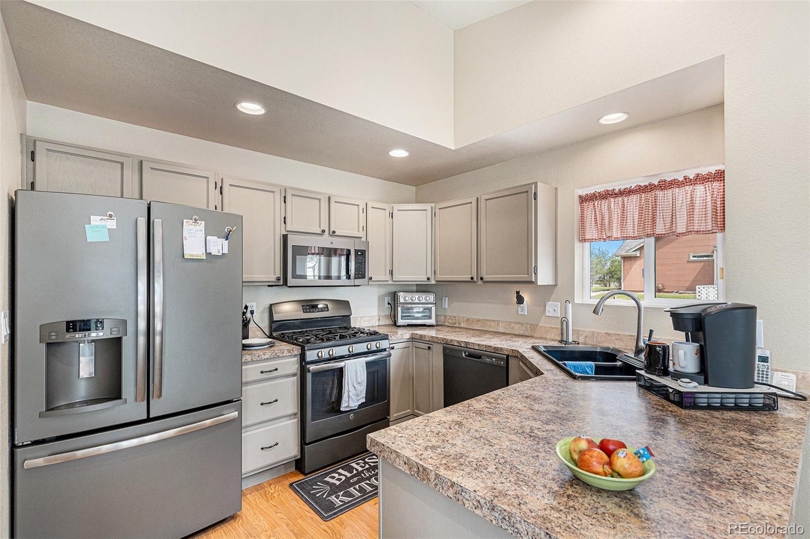 15482 Gadsden Drive Brighton, CO 80603 - Photo 14 of 43 a kitchen with kitchen island a stove a sink and a refrigerator