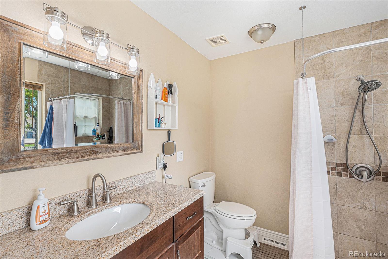 15482 Gadsden Drive Brighton, CO 80603 - Photo 18 of 43 a bathroom with a granite countertop sink toilet a mirror and shower