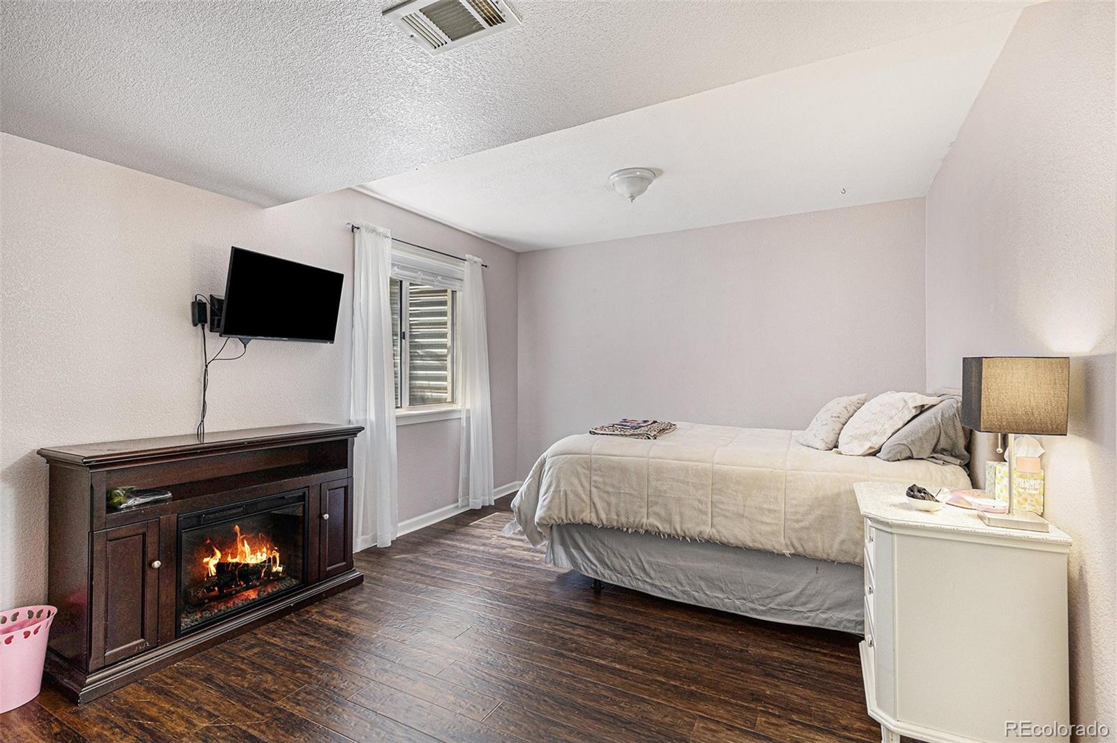 15482 Gadsden Drive Brighton, CO 80603 - Photo 27 of 43 a bedroom with a bed and a fireplace