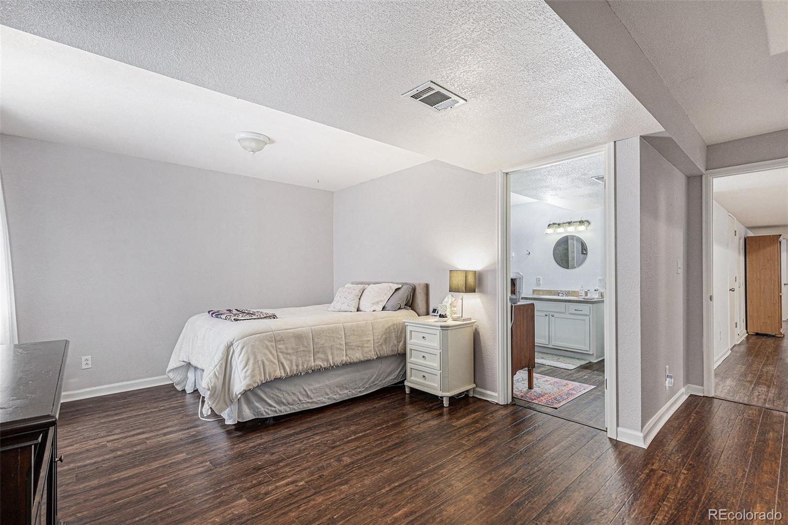 15482 Gadsden Drive Brighton, CO 80603 - Photo 28 of 43 a spacious bedroom with a bed and a tv