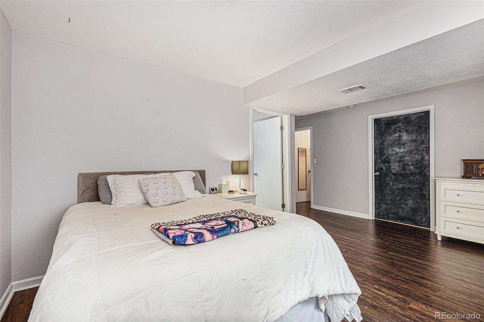 15482 Gadsden Drive Brighton, CO 80603 - Photo 29 of 43 a bedroom with a bed and wooden floor