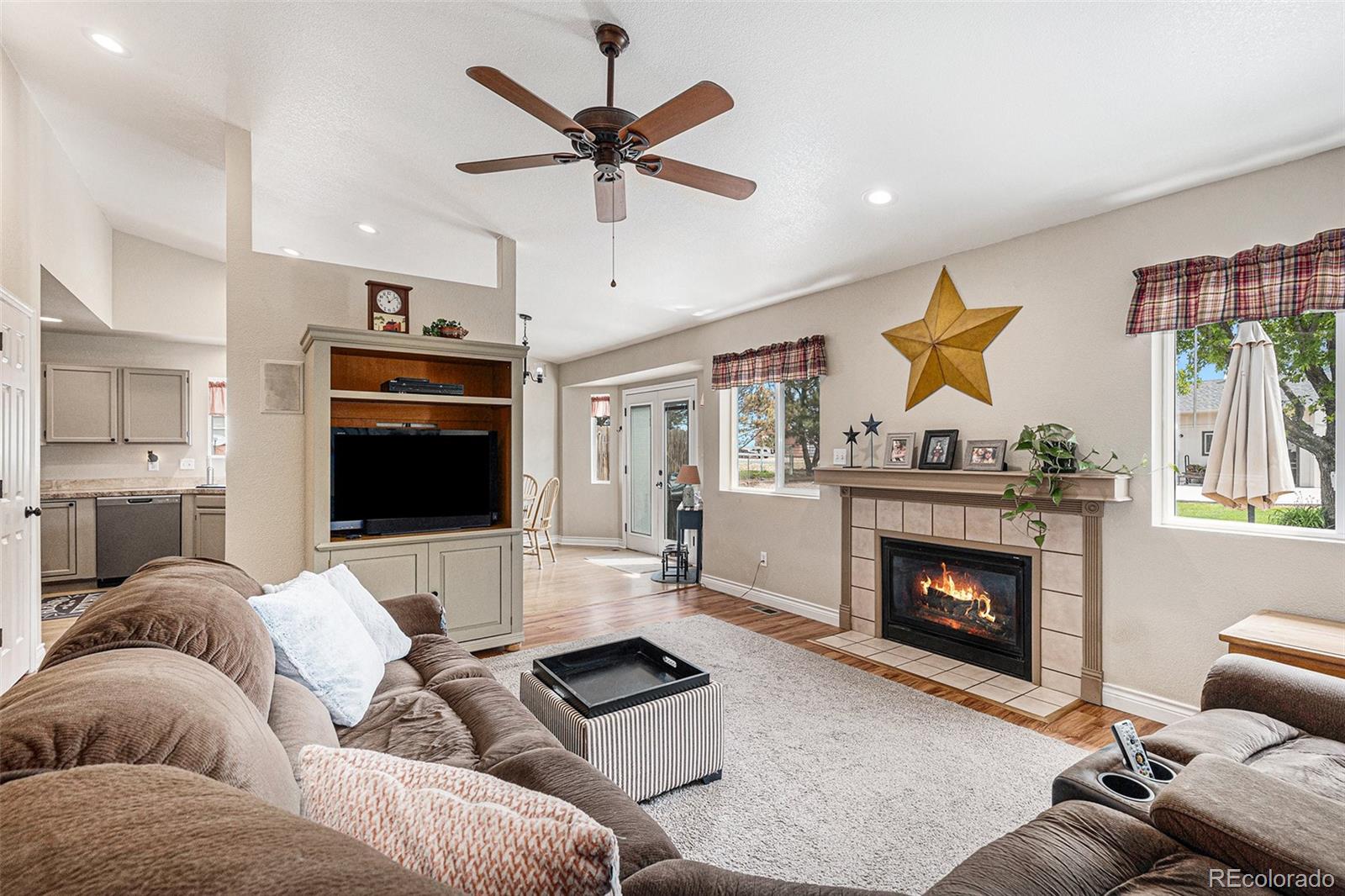 15482 Gadsden Drive Brighton, CO 80603 - Photo 10 of 43 a living room with furniture a flat screen tv and a fireplace