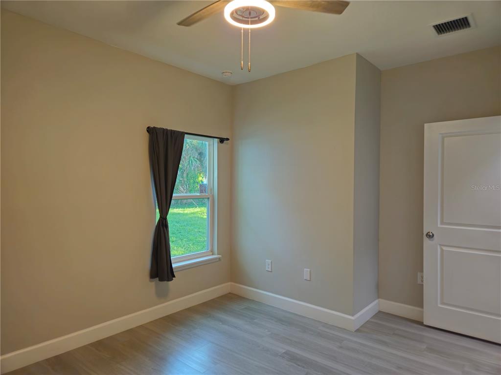 3633 Main Street Sanford, FL 32771 - Photo 13 of 17 a view of an empty room with wooden floor and a window