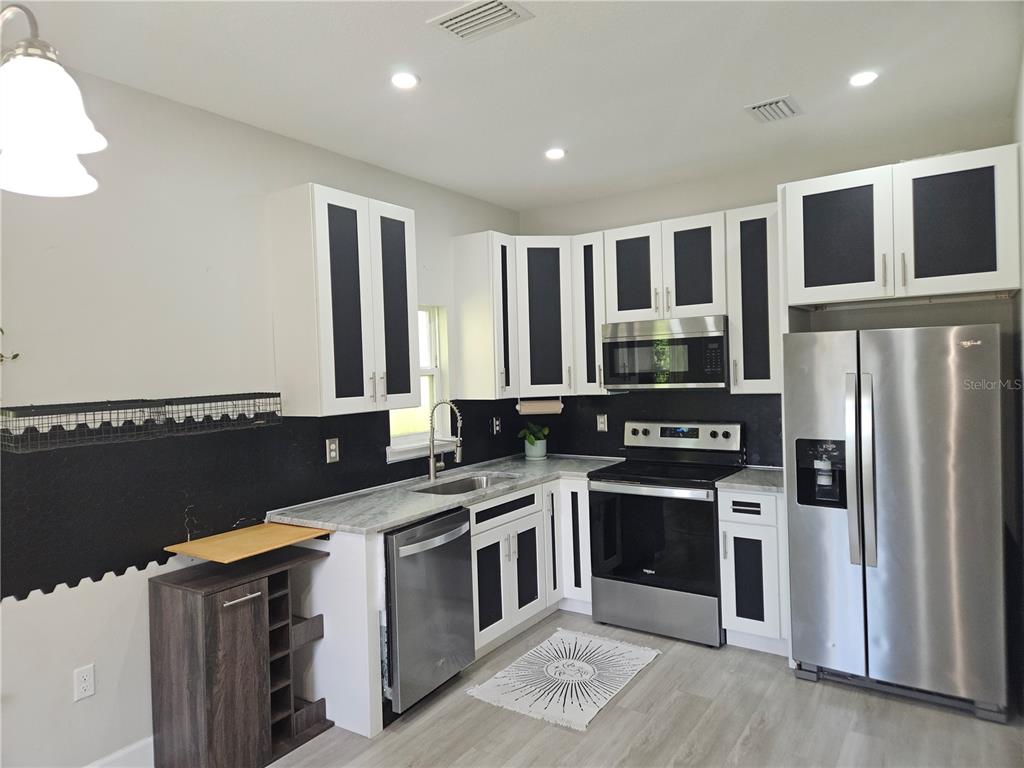 3633 Main Street Sanford, FL 32771 - Photo 5 of 17 a kitchen with stainless steel appliances granite countertop a stove a sink and a refrigerator