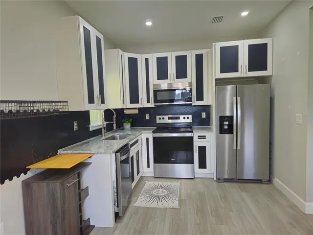 a kitchen with stainless steel appliances granite countertop a stove a refrigerator and a microwave