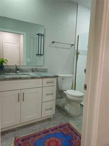 a bathroom with a sink a toilet and a mirror