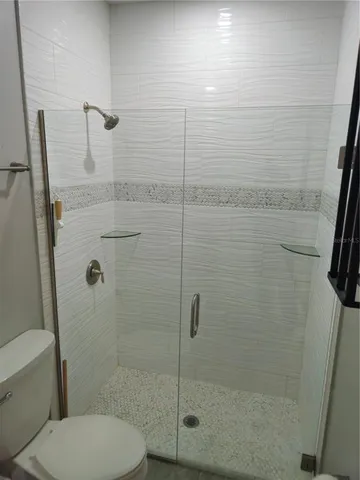 a bathroom with a toilet and a shower
