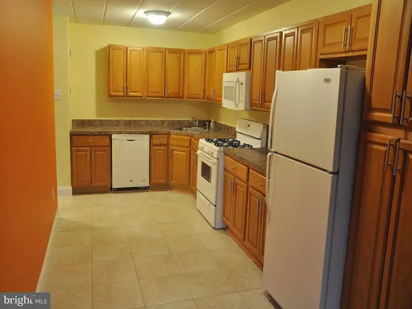 a kitchen with a refrigerator sink stove and cabinets