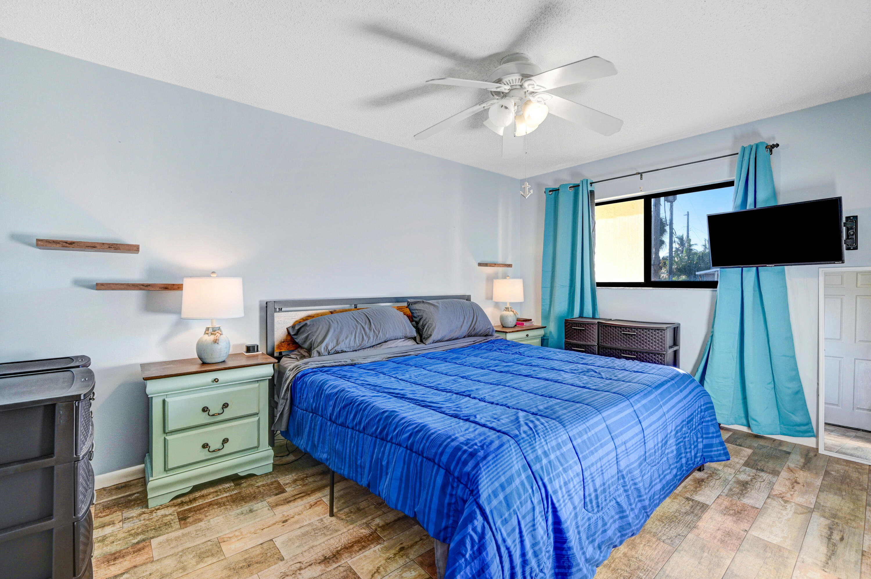 6655 Ridgewood Avenue, Unit 104 Cocoa Beach, FL 32931 - Photo 15 of 25 a bedroom with a large bed and a tv on dresser