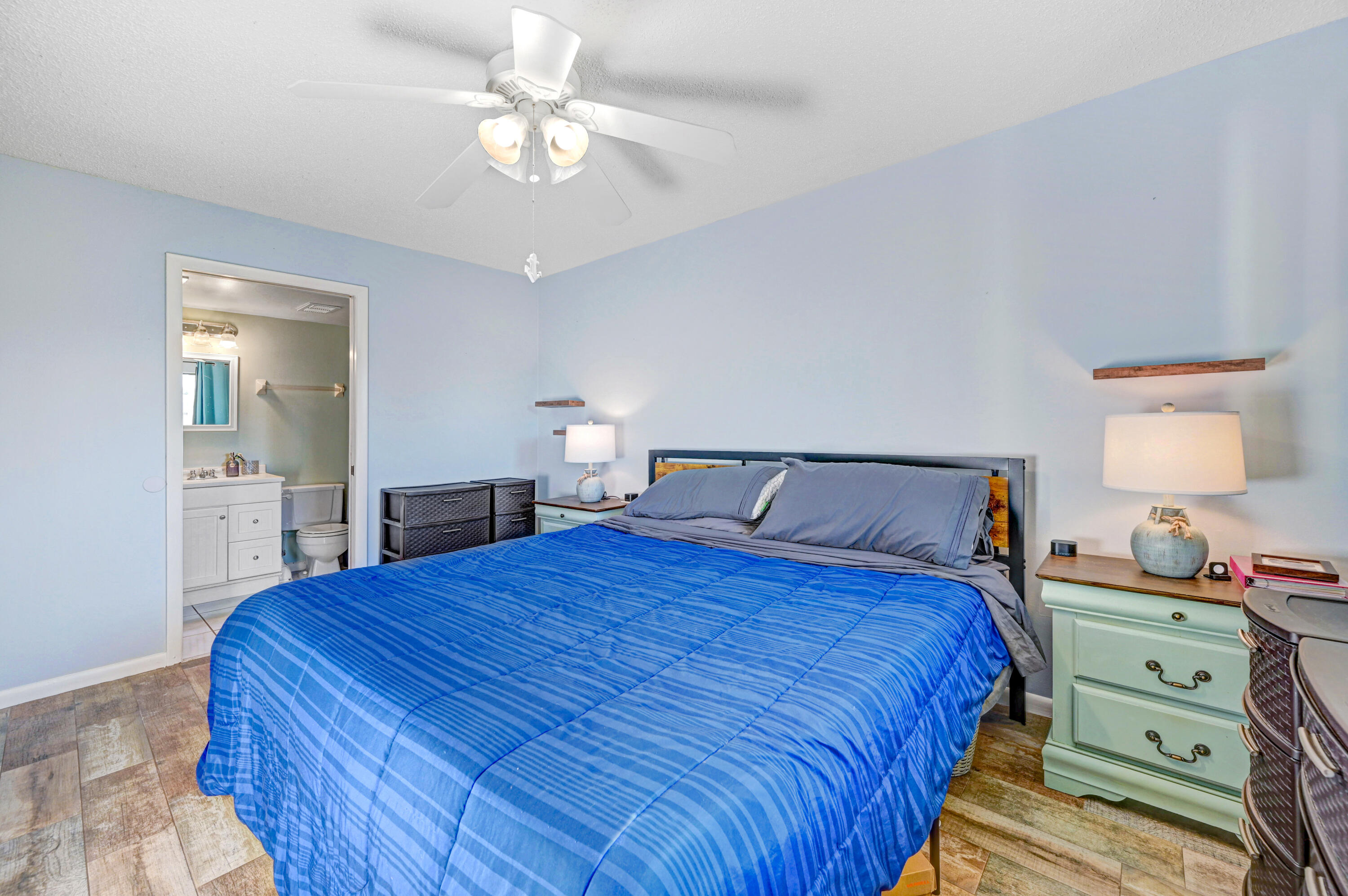 6655 Ridgewood Avenue, Unit 104 Cocoa Beach, FL 32931 - Photo 16 of 25 a bedroom with a bed and a lamp on dresser