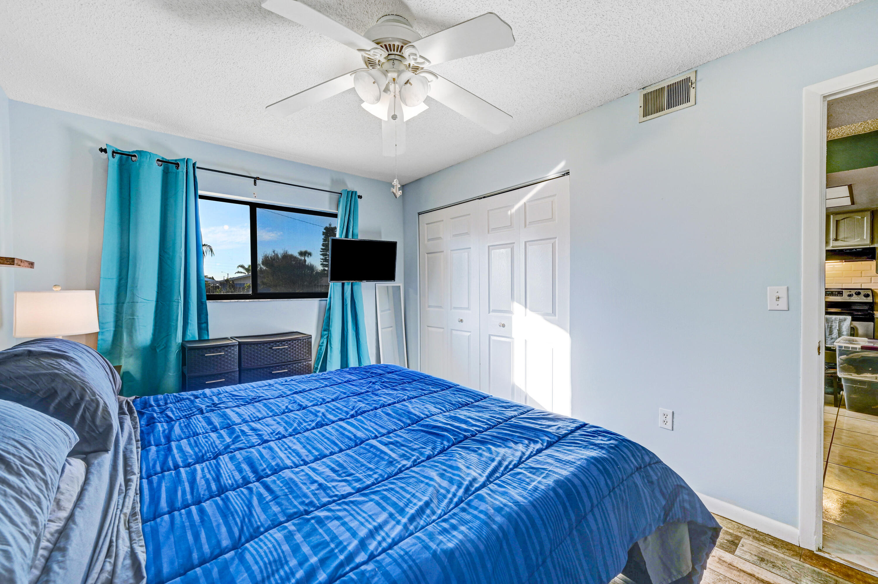 6655 Ridgewood Avenue, Unit 104 Cocoa Beach, FL 32931 - Photo 17 of 25 a bedroom with a large bed and a chandelier