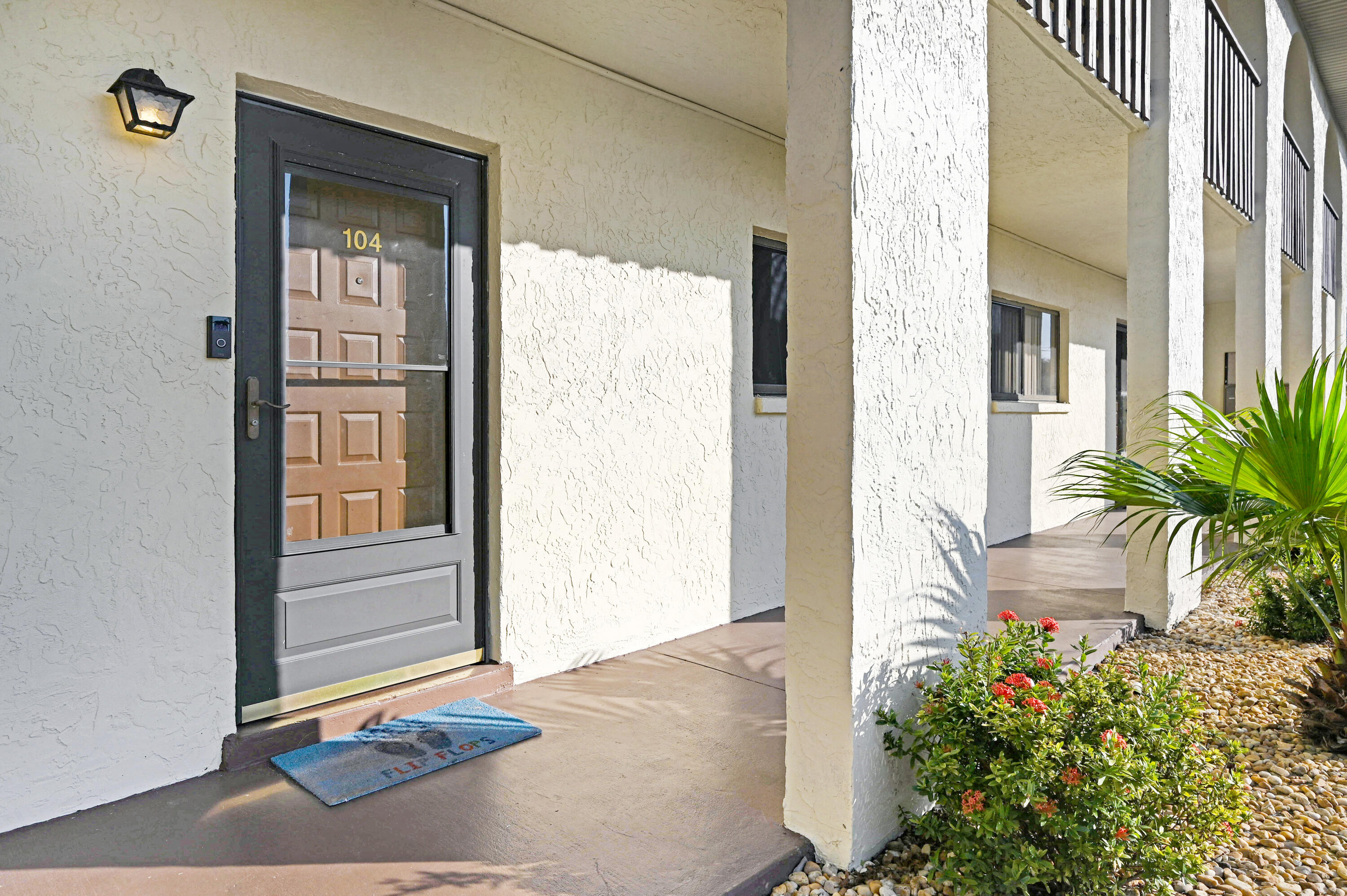 6655 Ridgewood Avenue, Unit 104 Cocoa Beach, FL 32931 - Photo 2 of 25 a front view of a house with a yard