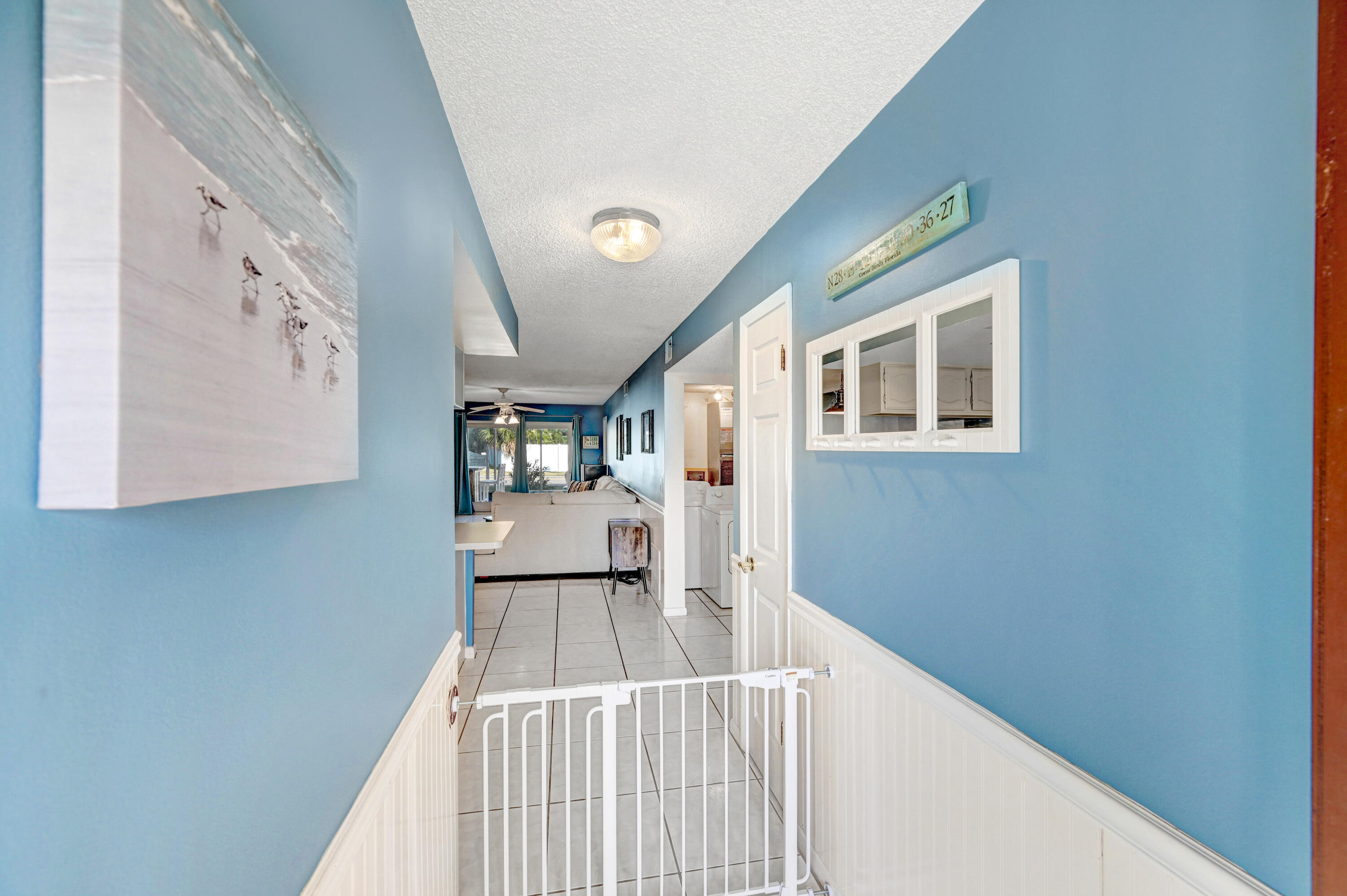 6655 Ridgewood Avenue, Unit 104 Cocoa Beach, FL 32931 - Photo 4 of 25 a view of a hallway to a house with wooden floor