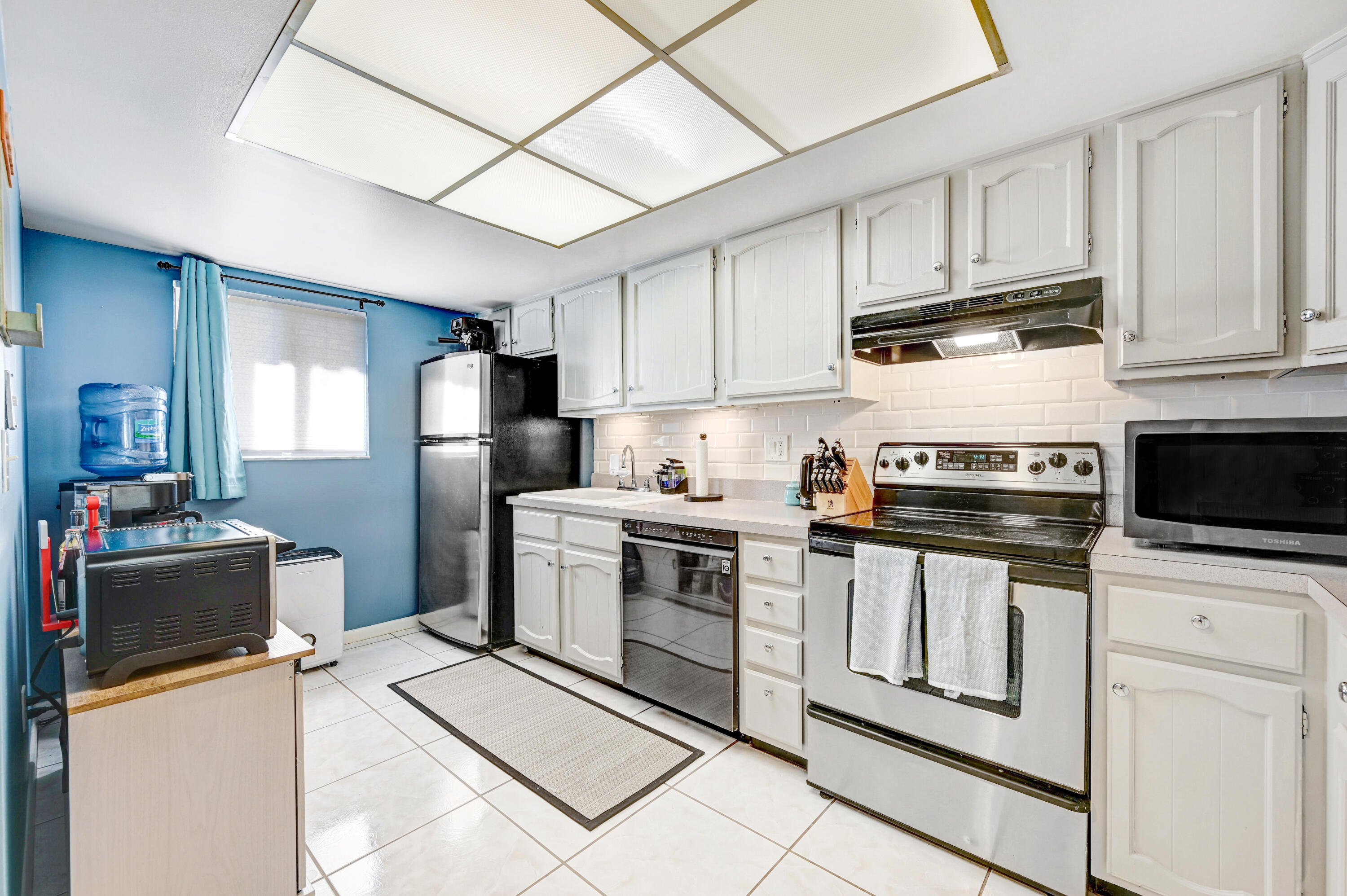 6655 Ridgewood Avenue, Unit 104 Cocoa Beach, FL 32931 - Photo 5 of 25 a kitchen with stainless steel appliances granite countertop a refrigerator stove a sink and dishwasher