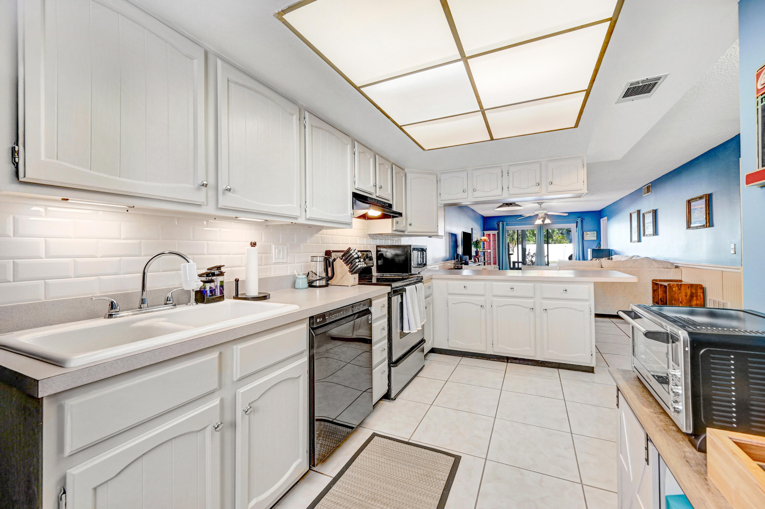 6655 Ridgewood Avenue, Unit 104 Cocoa Beach, FL 32931 - Photo 6 of 25 a kitchen with stainless steel appliances granite countertop a sink a stove and cabinets