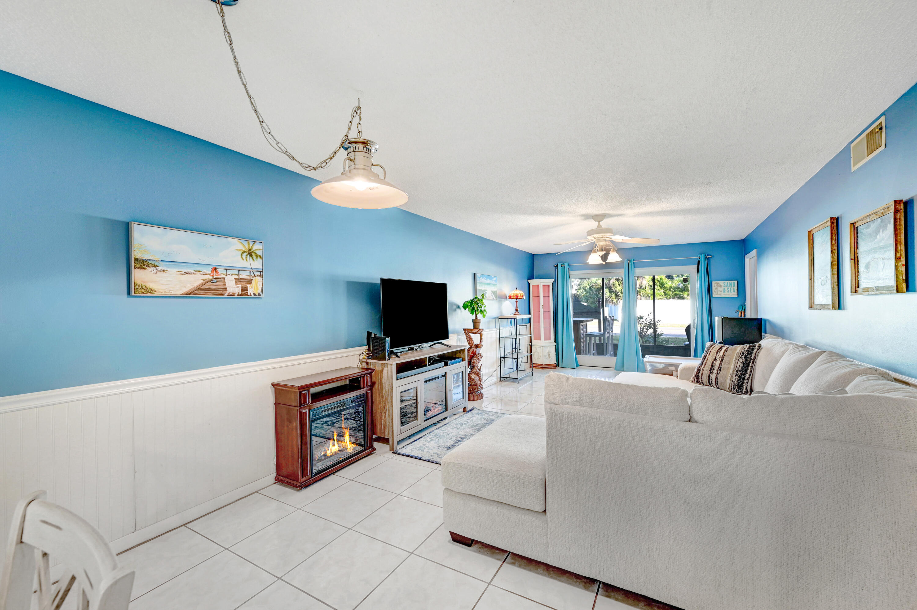 6655 Ridgewood Avenue, Unit 104 Cocoa Beach, FL 32931 - Photo 8 of 25 a living room with furniture and a flat screen tv