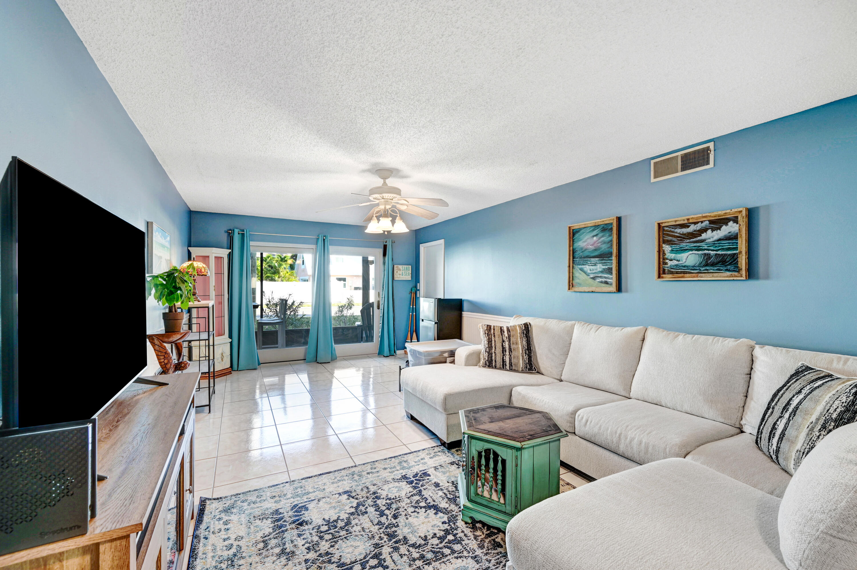 6655 Ridgewood Avenue, Unit 104 Cocoa Beach, FL 32931 - Photo 9 of 25 a living room with furniture and a flat screen tv